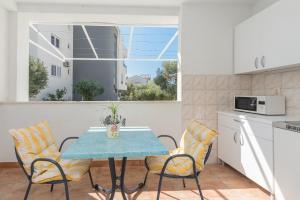 a kitchen and dining room with a table and chairs at Apartmants Šestić in Tučepi