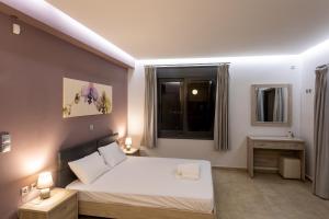 a bedroom with a white bed and a window at Saronic TopView Villa in Galatas