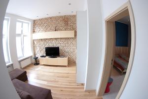 a living room with a brick wall and a television at Classic Apartment with Private Sauna in Old Town in Gdańsk