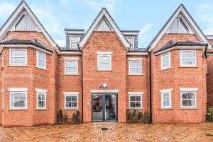 una imagen de una casa de ladrillo rojo con ventanas blancas en 2 Bedroom City Centre Apartment in High Wycombe with Parking en High Wycombe