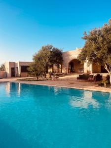 una gran piscina de agua azul frente a un edificio en Villa Kyanite, en Essaouira