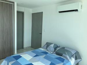 - une chambre avec une couverture bleue et blanche sur un lit dans l'établissement Lovely flat with pool in city center, à Panama City