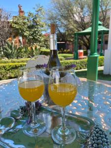 dos copas de vino sentadas en una mesa con una botella en Hotel El Mirador en Tequisquiapan