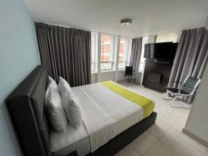 a bedroom with a bed with a television and a couch at Hotel Tupinamba Neiva in Neiva