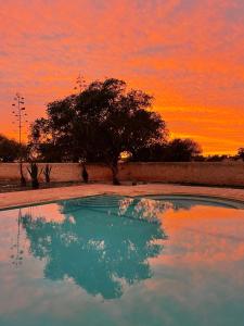 una piscina de agua con una puesta de sol en el fondo en Villa Kyanite, en Essaouira