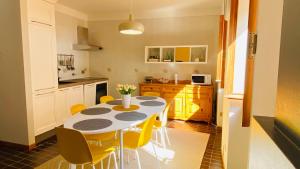 a kitchen with a table and some yellow chairs at La casa della Rocca - MonferratoHome in Camagna Monferrato