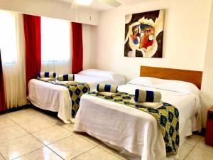 een hotelkamer met vier bedden in een kamer bij 3 Room Beach Condo, Great for Family and Friends! in Cancun