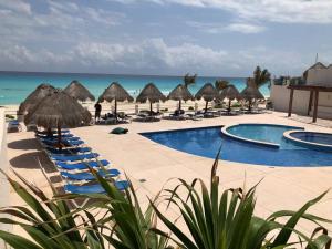 een resort met stoelen en parasols op het strand bij 3 Room Beach Condo, Great for Family and Friends! in Cancun
