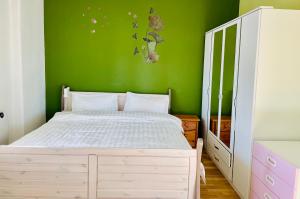 a bedroom with a white bed and a green wall at New living Home in Seevetal