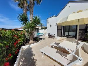 a patio with white tables and chairs and flowers at Sol y Luna Room & Suite Lanzarote Holidays - Heated pool! in Playa Blanca +1 photo