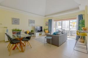 a living room with a table and a couch at Penthouse Cassia in Cabanas de Tavira