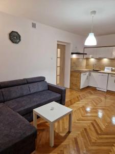 a living room with a couch and a table and a kitchen at Apartament w Centrum in Prudnik