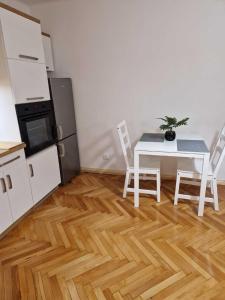 kuchnia ze stołem i krzesłami w pokoju w obiekcie Apartament w Centrum w mieście Prudnik