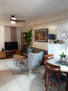 uma sala de estar com uma mesa e cadeiras e uma televisão em The Redwoods Fairview Quezon City em Manila