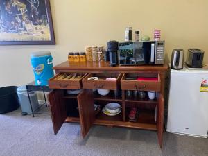 a wooden shelf with a microwave and a refrigerator at Luxury on Howden in Te Anau