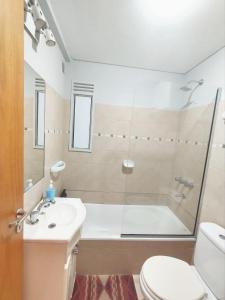 a bathroom with a tub and a sink and a toilet at Depto San Lorenzo in Rosario