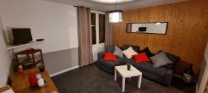 Una sala de estar con un sofá y un televisor en Studio 57, en Orcières