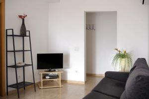 un soggiorno con divano e TV su un tavolo di Aparthotel Iris a Malgrat de Mar