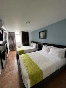 a hotel room with two beds and a television at Hotel Tupinamba Neiva in Neiva