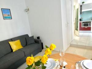 salon z kanapą i stołem z żółtymi różami w obiekcie Marceau Central Flat w Nicei