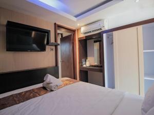 a hotel room with a bed with a flat screen tv at Sari Gili Bungalow in Gili Islands