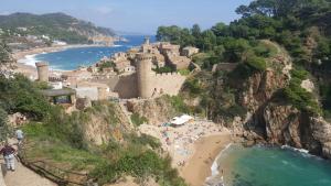 a group of people on a beach next to a castle at Apartamento con Parking a 200m del mar in Tossa de Mar