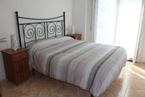 a bedroom with a large bed with a wooden night stand at Apartamento con Parking a 200m del mar in Tossa de Mar