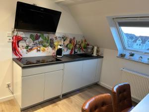uma cozinha com um lavatório e uma televisão de ecrã plano em Ferienwohnung Nella em Paderborn