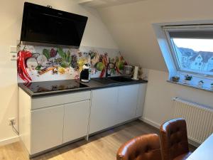 cocina con fregadero y TV de pantalla plana. en Ferienwohnung Nella, en Paderborn