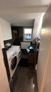 Ferienwohnung Nella في بادربورن: حمام صغير مع غسالة ملابس ونافذة