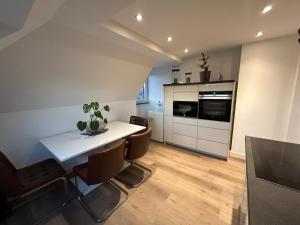 uma cozinha com uma mesa branca e algumas cadeiras e um balcão em Ferienwohnung Nella em Paderborn