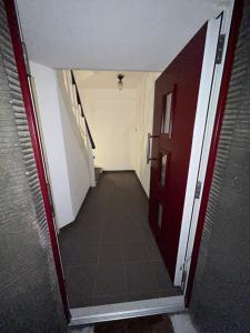 a hallway with a red door and a tile floor at Ferienwohnung Nella in Paderborn
