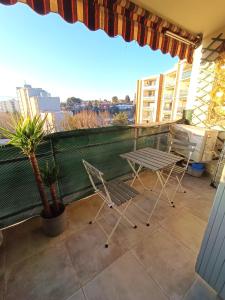 d'une terrasse avec 2 chaises et une table sur un balcon. dans l'établissement Appartement climatisé terrasse parking 8 couchages, à Marseille