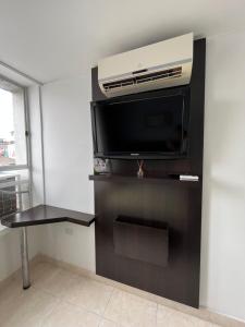 a room with a flat screen tv on a wall at Hotel Tupinamba Neiva in Neiva