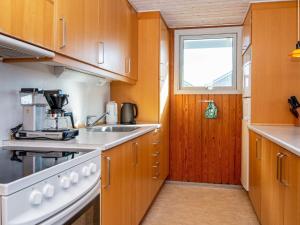 eine Küche mit einem Herd, einem Waschbecken und einem Fenster in der Unterkunft 8 person holiday home in Harbo re in Harboør