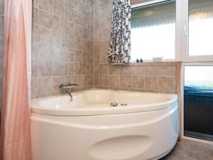 baño con aseo y bañera con ventana en 8 person holiday home in Hejls, en Hejls