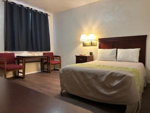 pokój hotelowy z łóżkiem, stołem i krzesłami w obiekcie Heritage Inn w mieście Uniontown