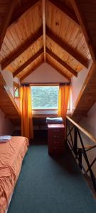 Habitación en el ático con cama y ventana en Casa Típica Fueguina- Departamento 2 y 3 en Ushuaia