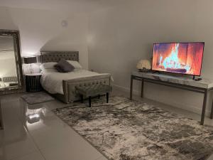 1 dormitorio con 1 cama y escritorio con TV en CF14 en Cardiff