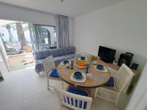 a dining room with a table and chairs and a couch at Palm Point in Costa Calma