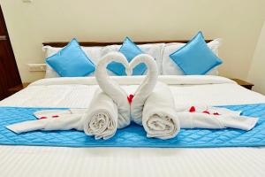 two swans are made into towels on a bed at Tirupati Homestay - Ragunatha Resorts - 3BHK AC Apartments for large families - Best location - Flyover to Alipiri gate - Modular Kitchen - Super fast WiFi - Android TV - 250 Jio Channels - Easy access to visit all Temples in Tirupati