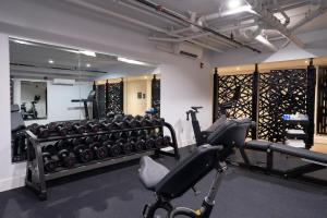 a gym with rows of exercise equipment in a room at The Maj Hotel in Philadelphia