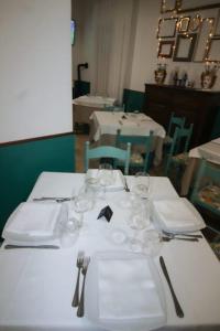 a table with white plates and wine glasses on it at Hotel dei Nebrodi in Cesarò