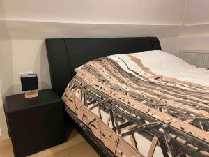 a bed with a black headboard and a black night stand at Apartment City Center Gouda in Gouda