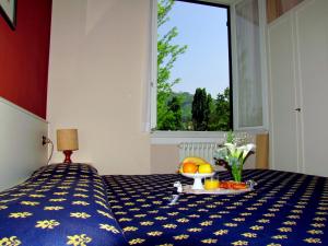 Un dormitorio con una cama con una bandeja de comida. en Park Hotel Salice Terme - OltrePò Pavese -, en Salice Terme