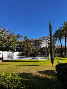 un parque con palmeras y un edificio al fondo en Estudio Marbella, en Marbella