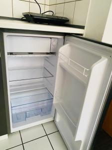 an empty refrigerator with its door open in a kitchen at PS-Projektentwicklung in Dortmund