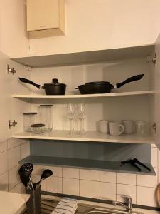 een keuken met planken met potten en pannen en glazen bij PS-Projektentwicklung in Dortmund
