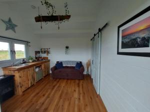 a living room with a couch in the corner of a room at Seafield Cabin in Tromra