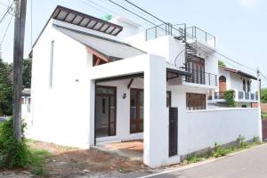 a white house with a black and white facade at Villa 61A - Capital of Sri Lanka in Pagoda